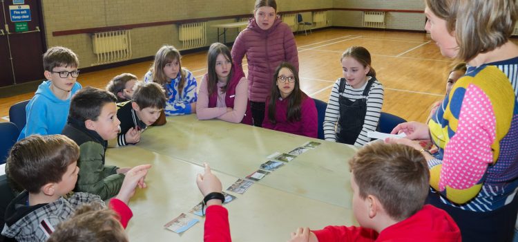 Children sitting around a table with a Sunday School leader asking questions.