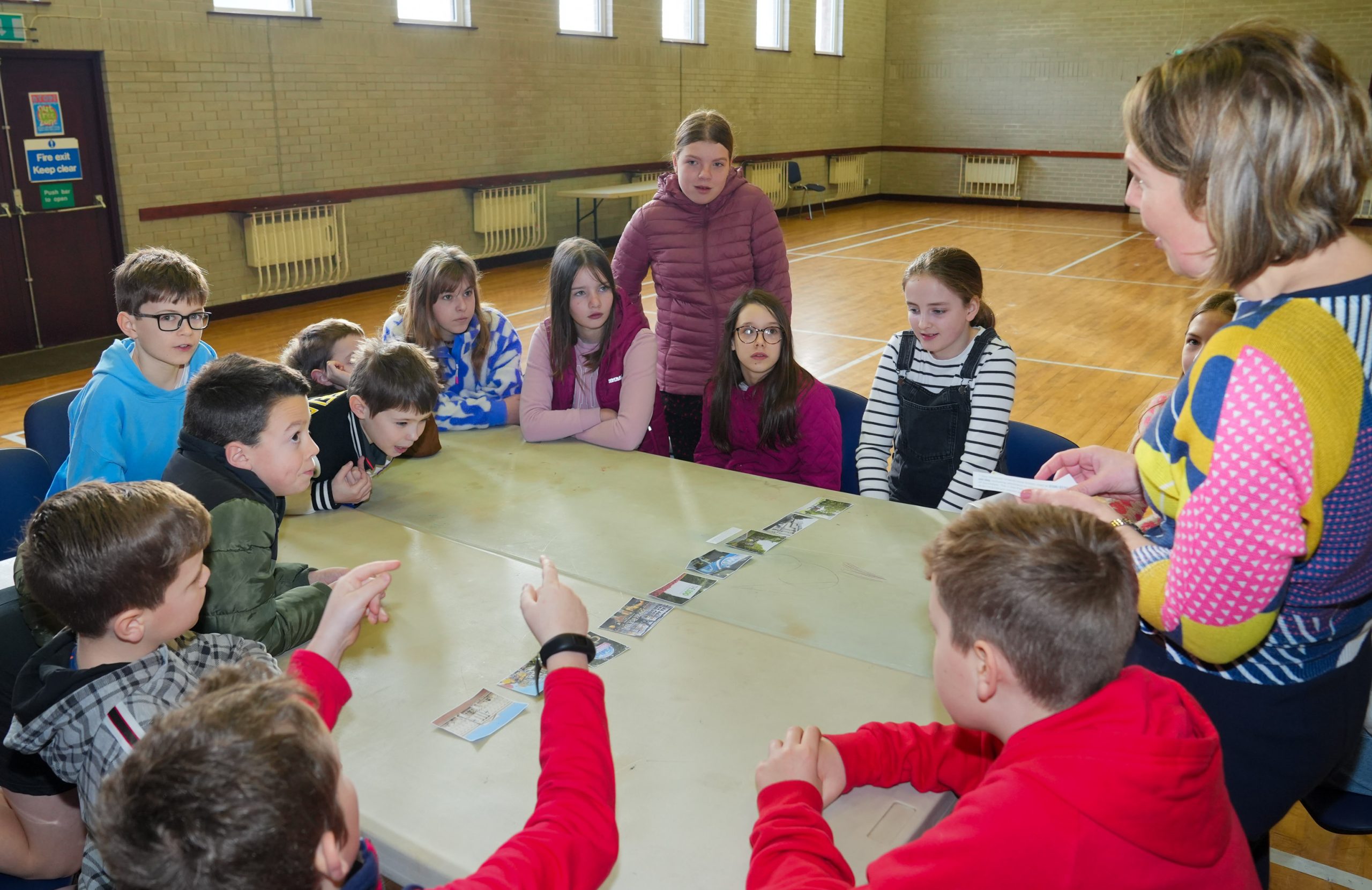 Children sitting around a table with a Sunday School leader asking questions.