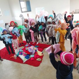 Children receiving knitted gifts from Helping Hands