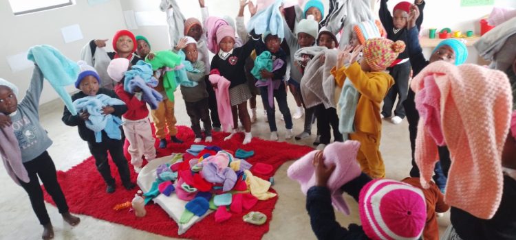 Children receiving knitted gifts from Helping Hands