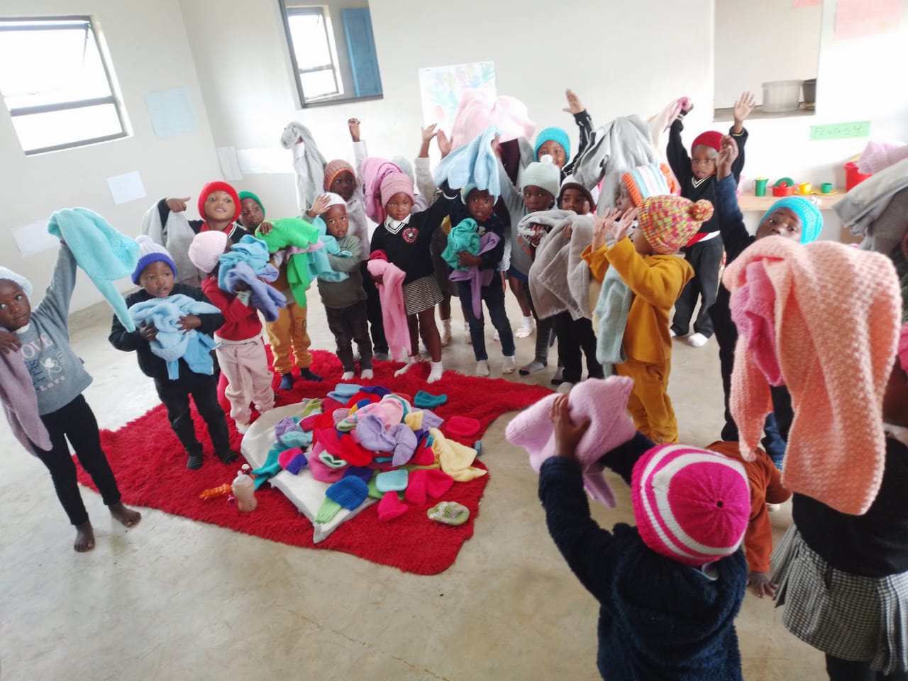 Children receiving knitted gifts from Helping Hands